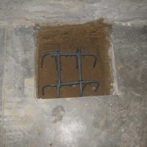 A hole in the ground with a metal bar in it.