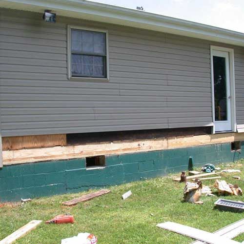 A house that is being remodeled with a lot of wood in front of it