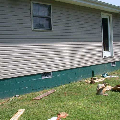 A house is sitting on top of a lush green lawn.