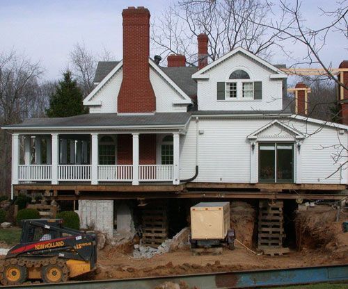 A new holland skid steer is moving a house