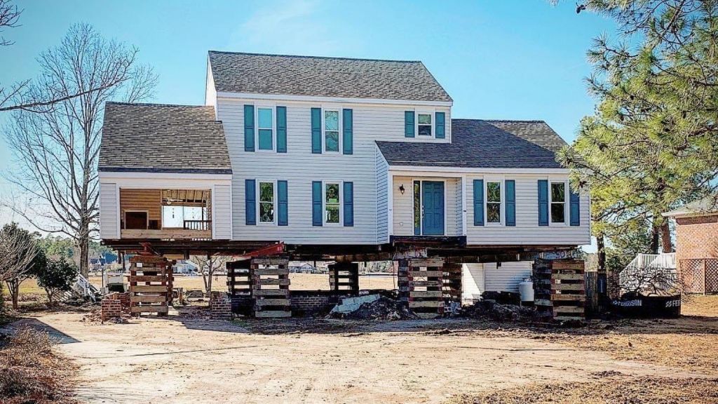 A large white house is being built on stilts.