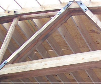 A close up of a wooden structure with metal brackets