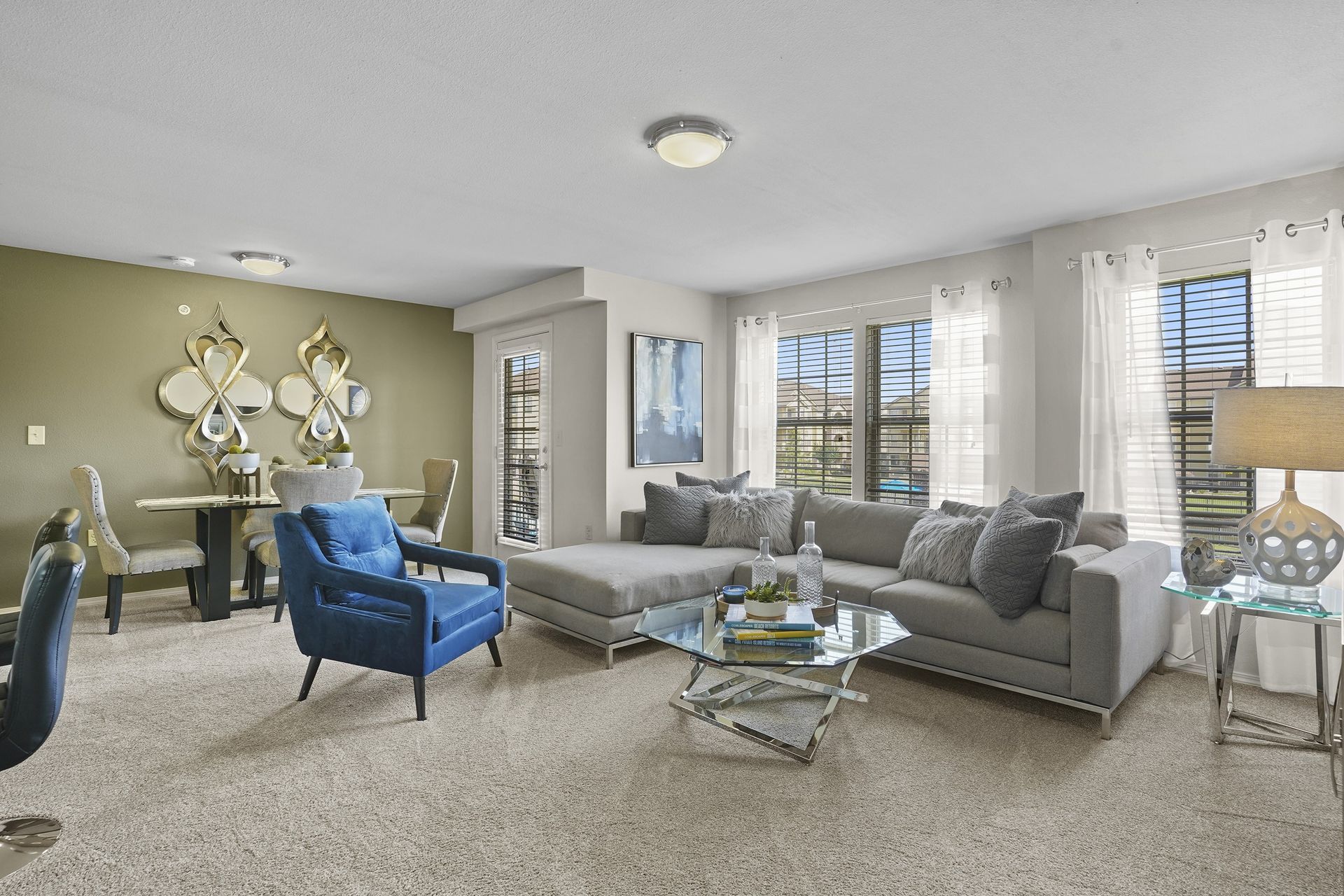 A living room with a blue chair and a grey couch.