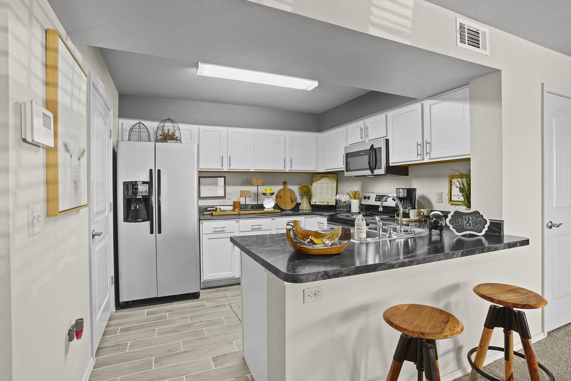 A kitchen with a black counter top and white cabinets.