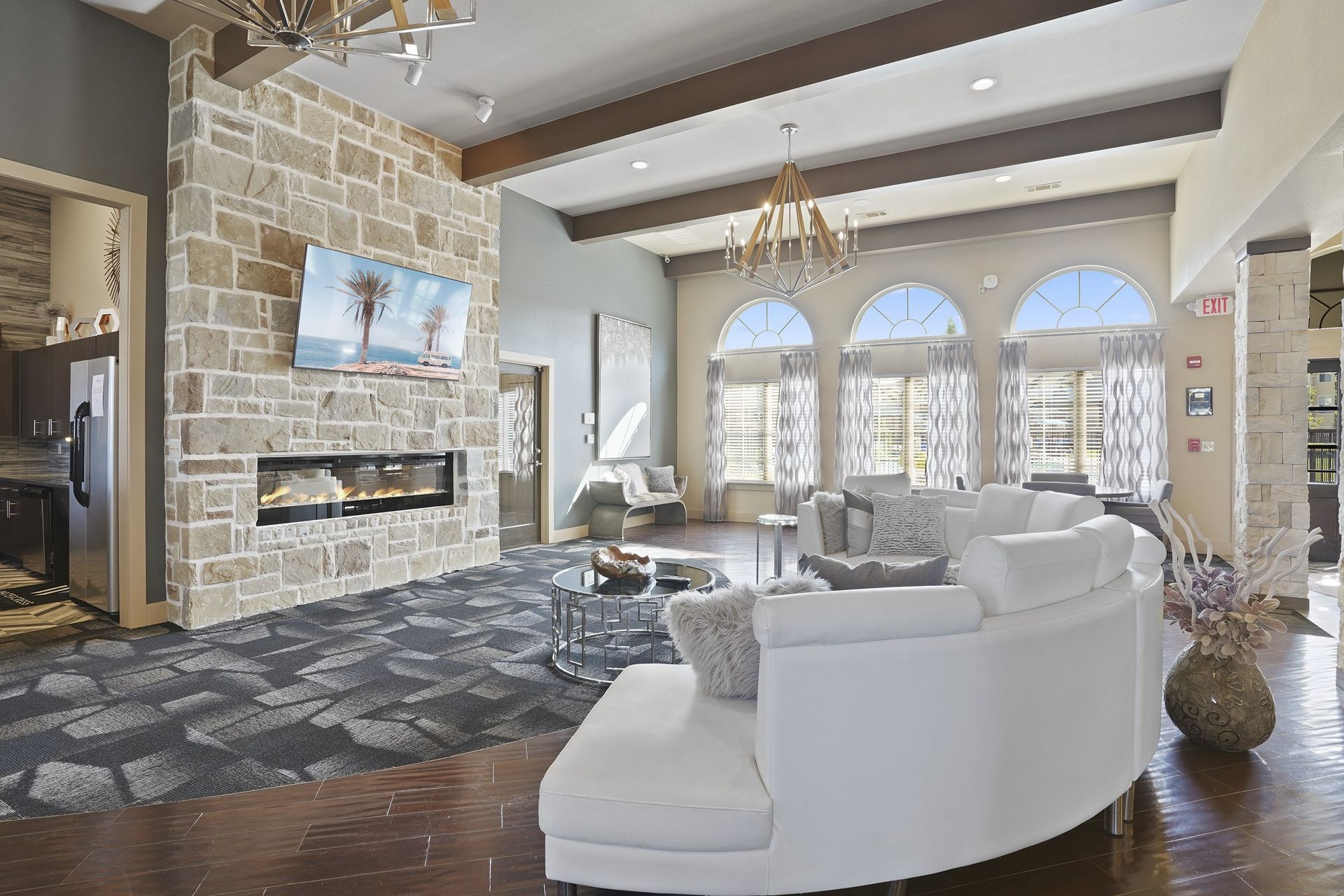A living room with a stone fireplace and a white couch.