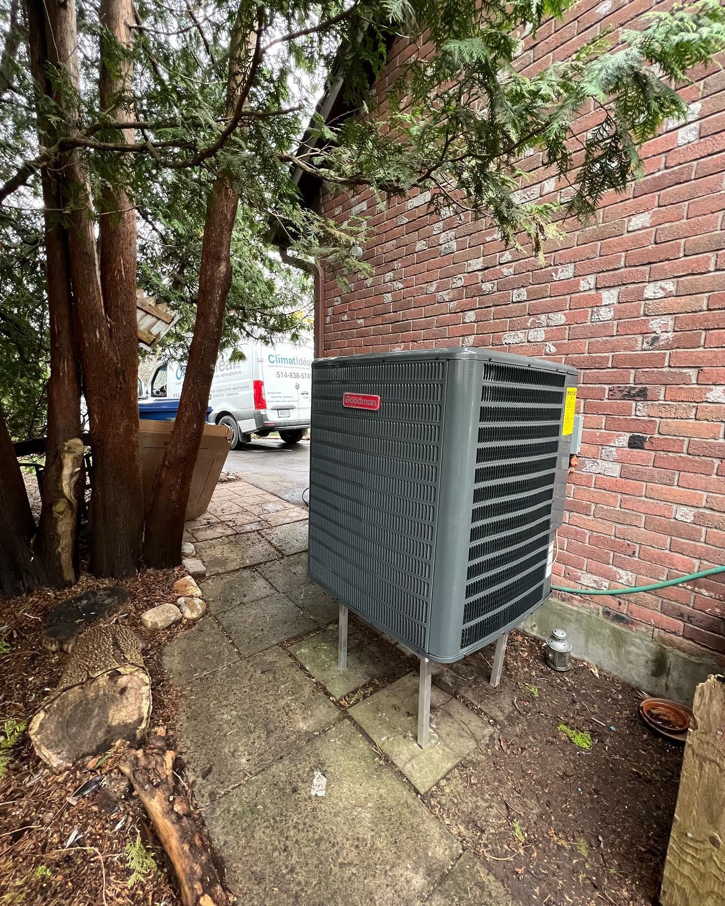 A large air conditioner is sitting on the side of a brick building.