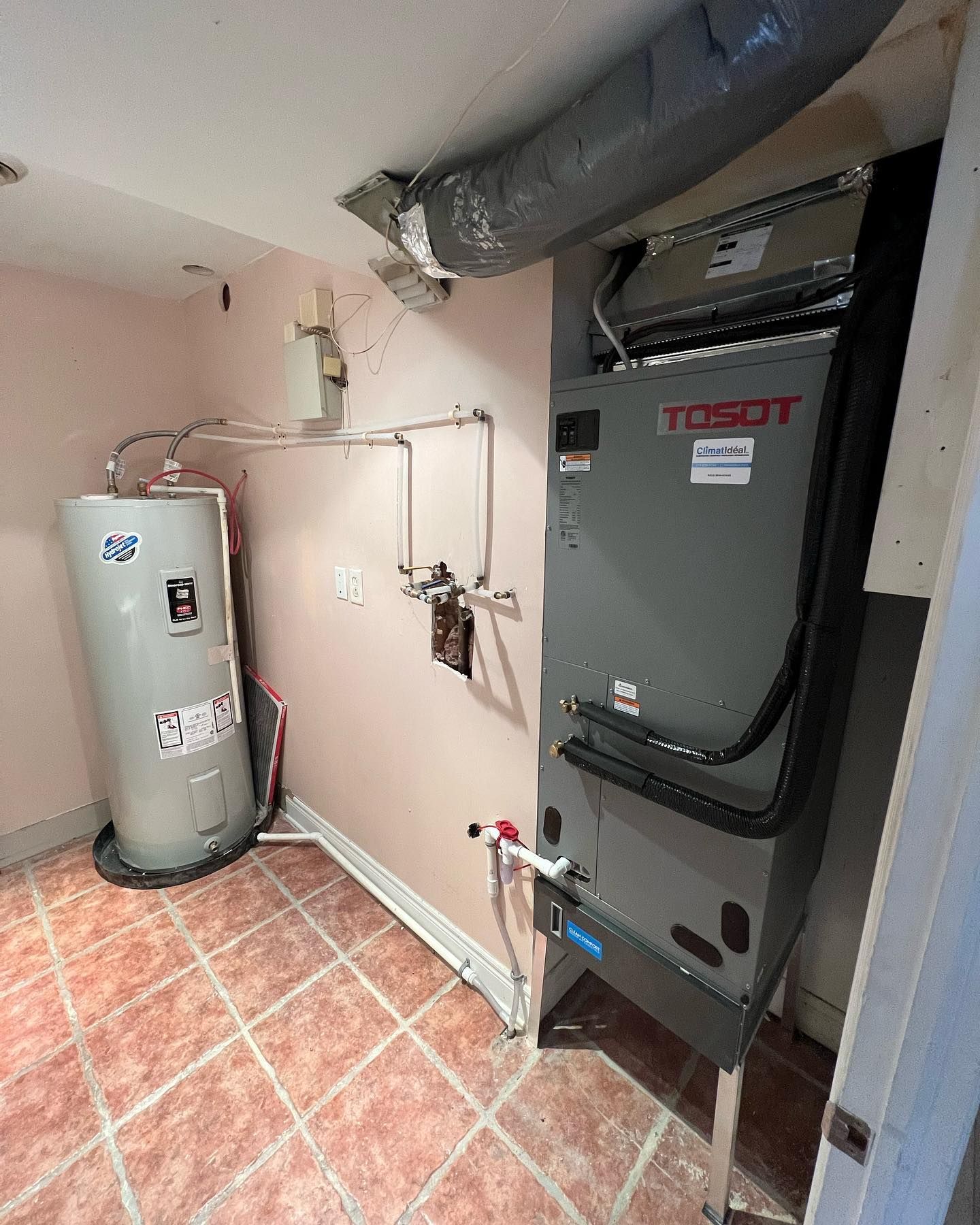 A room with a water heater and an air conditioner.