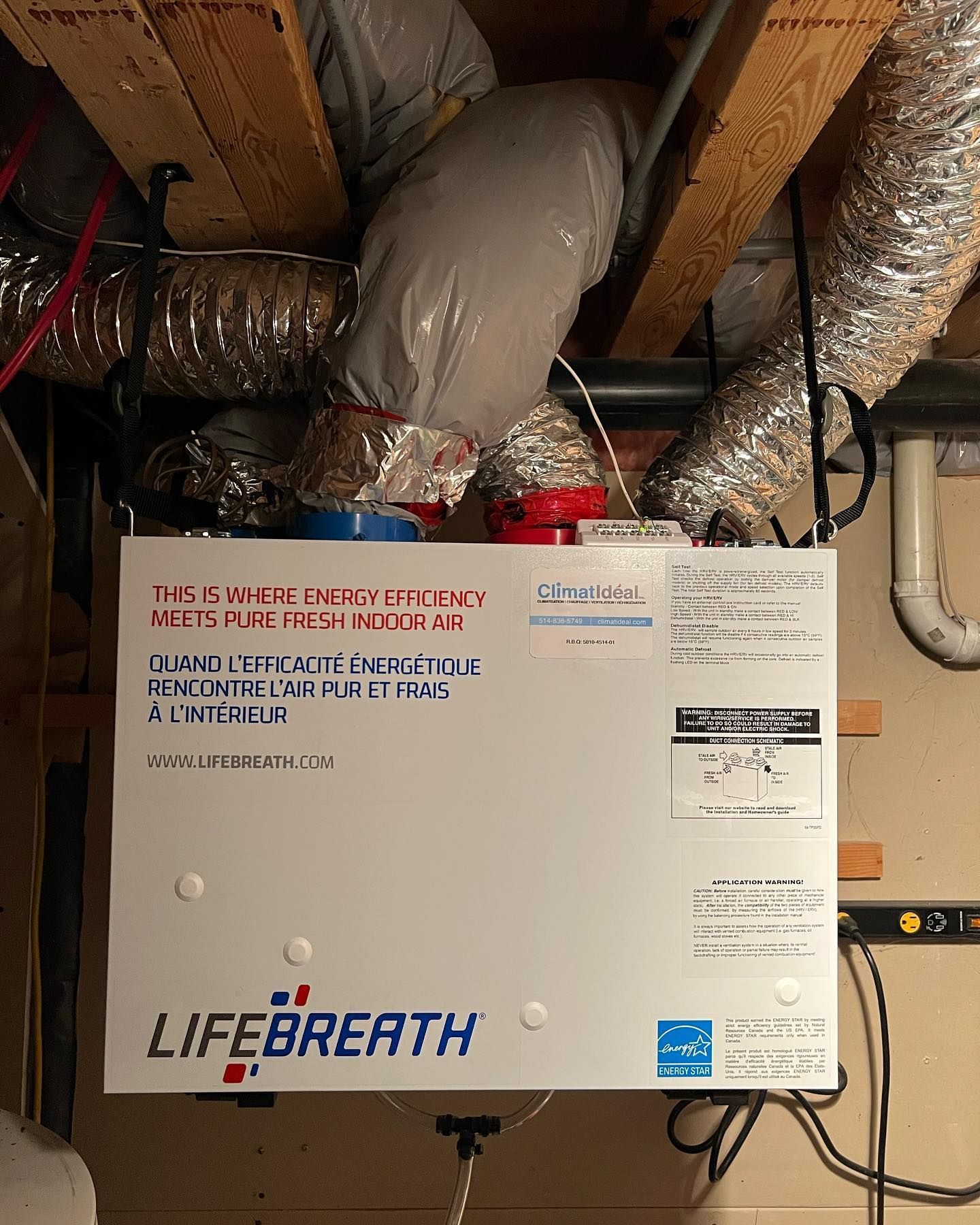 A life breath air purifier is hanging from the ceiling of a room.