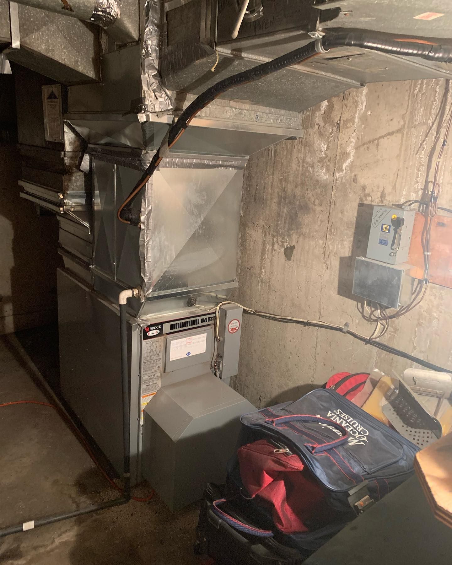 A room with a heater and a bag on the floor.