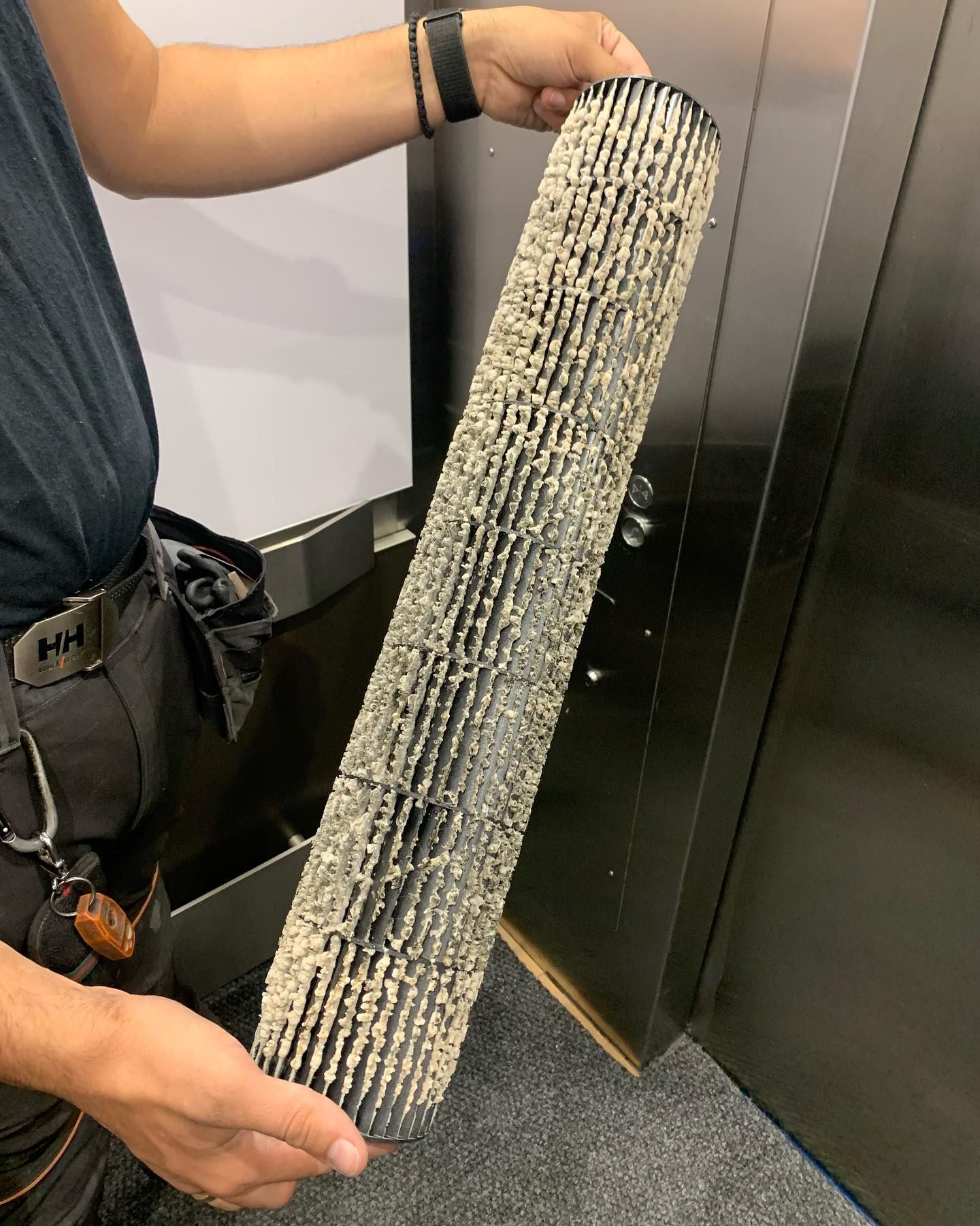 A man is holding a long piece of metal in his hands.