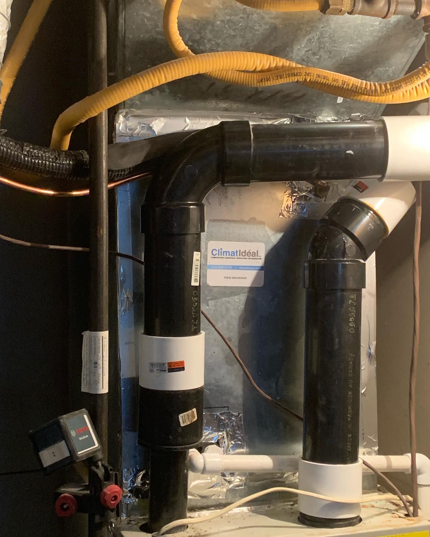 A close up of a heating system with pipes and wires.