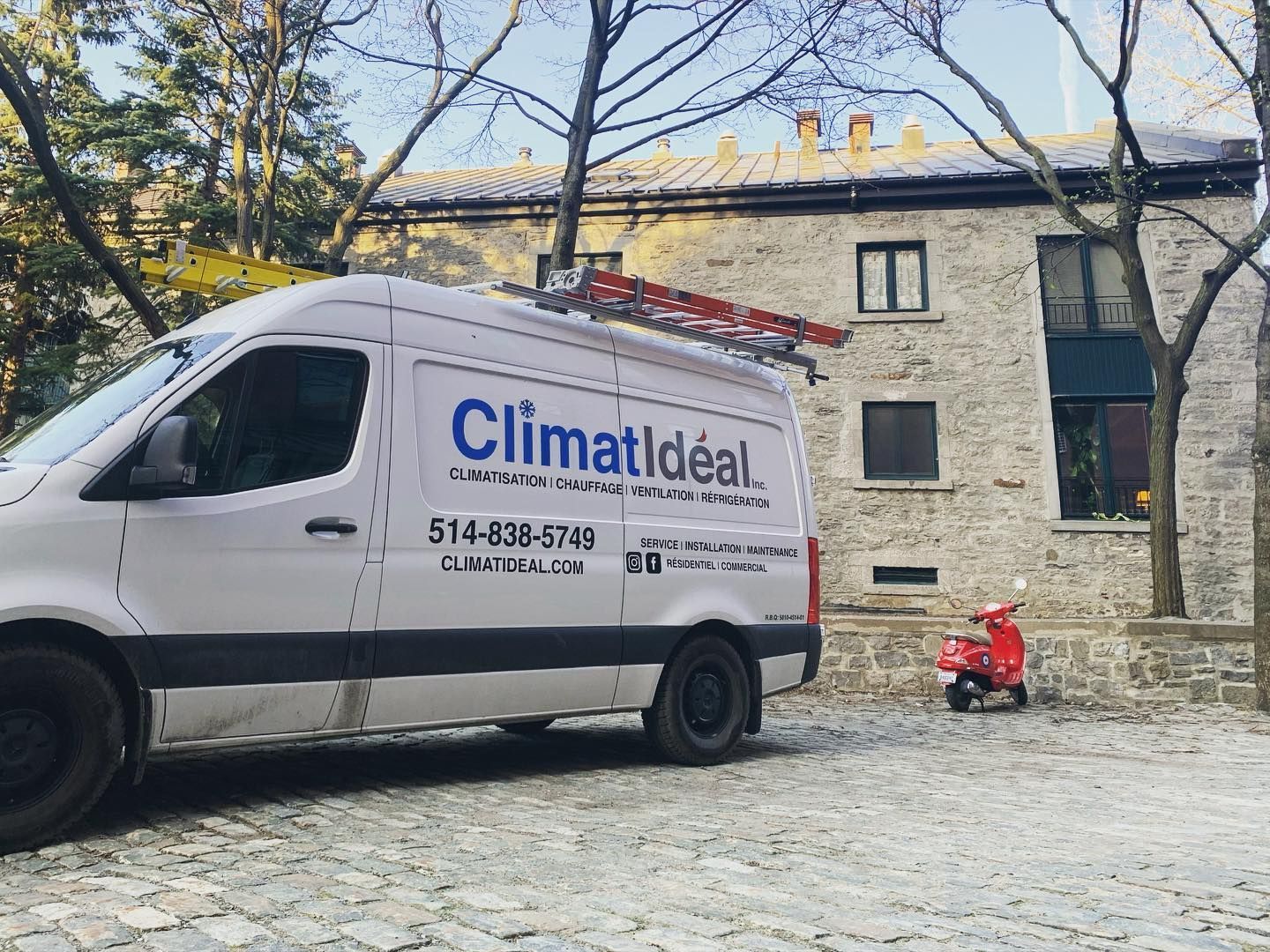 A white van with the word climat ideal on it is parked in front of a building.