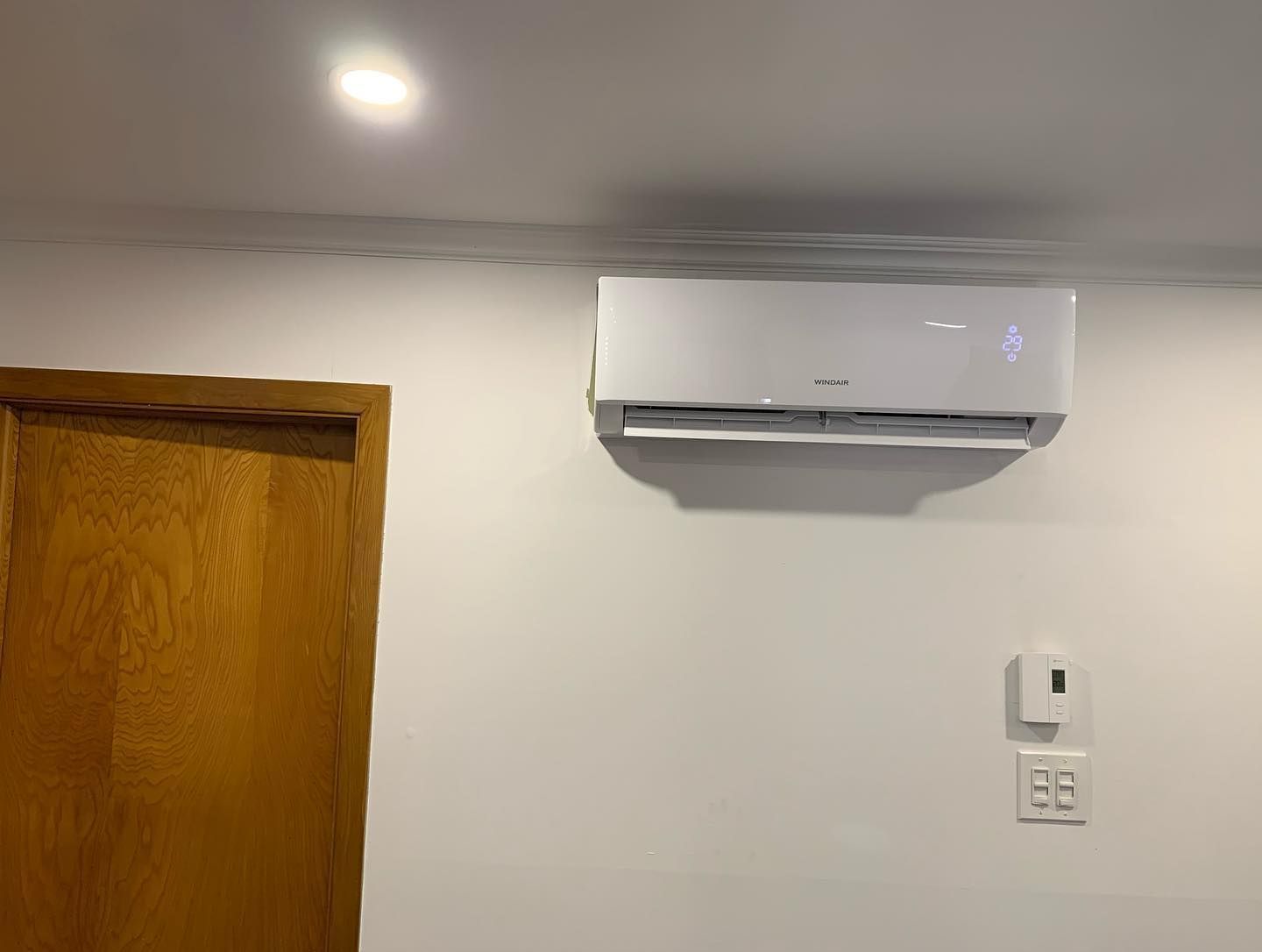 A room with a door and a wall mounted air conditioner.