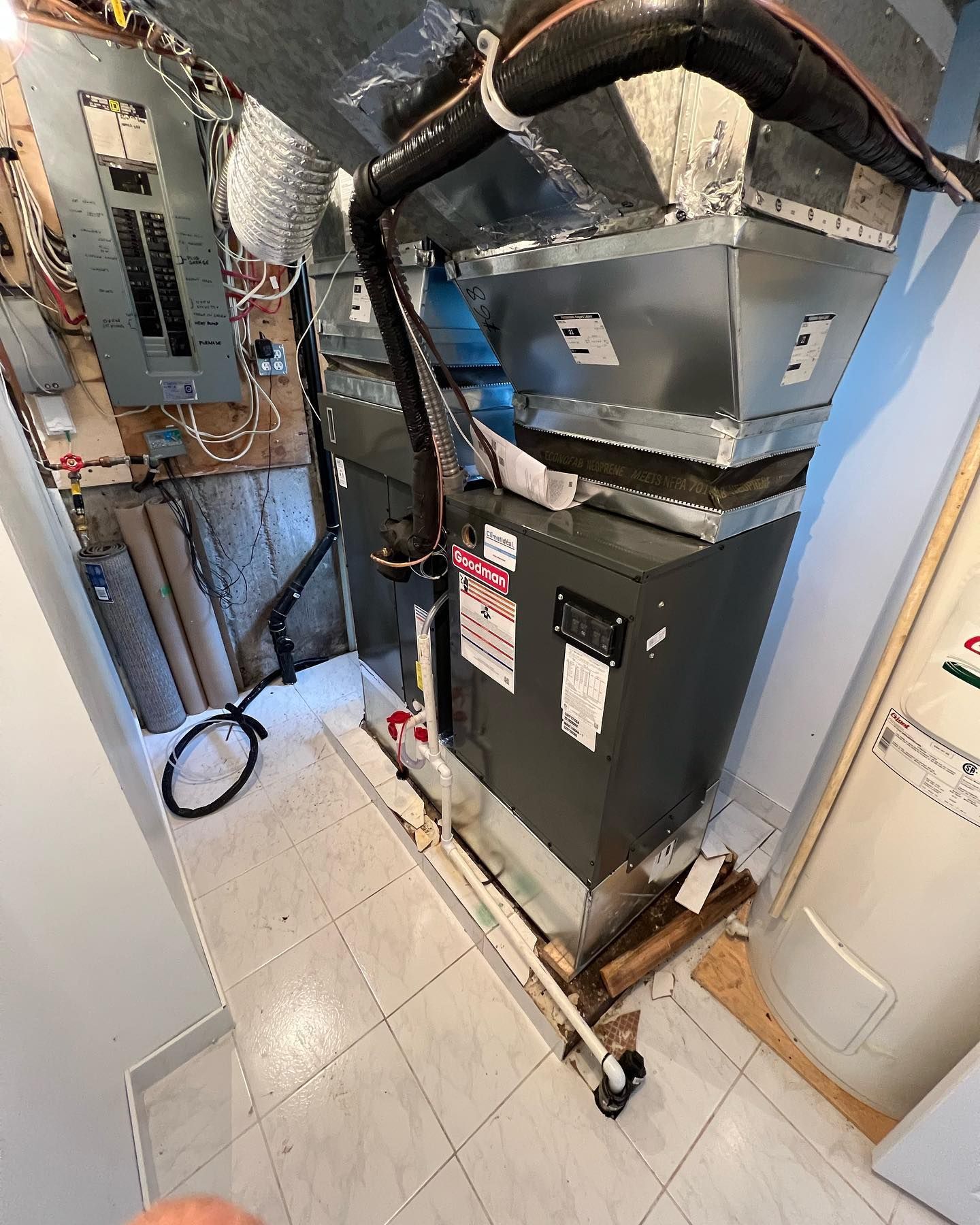 A person is standing next to a heater in a room.