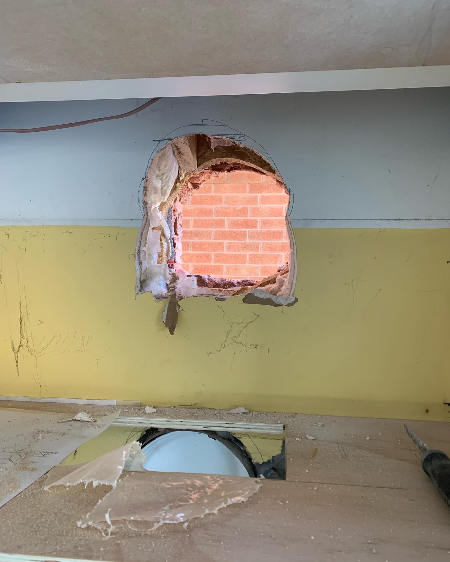 A hole in a wall with a brick in it