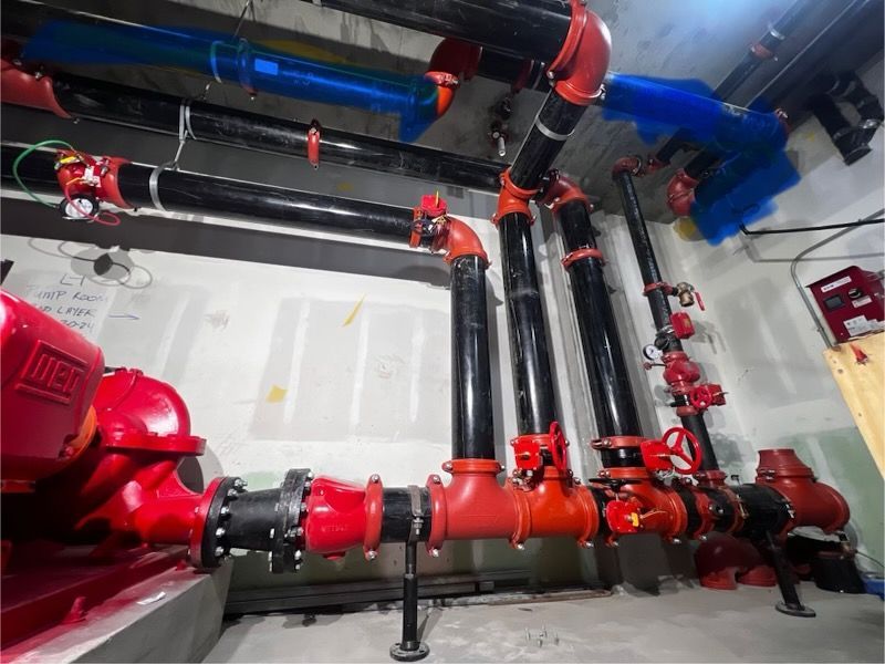 A room with a lot of pipes and a red pump that says jvc on it