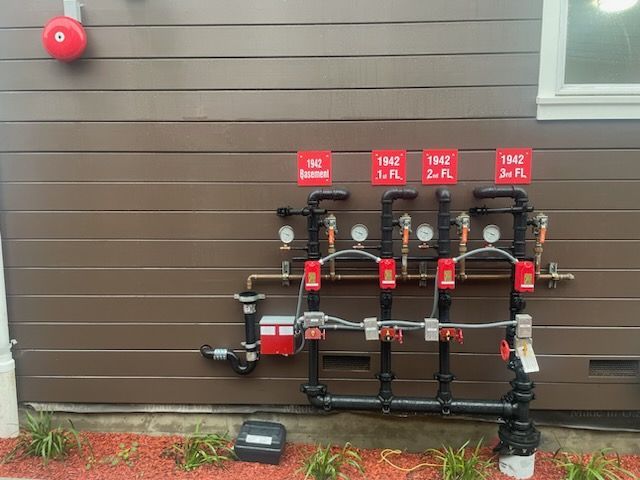 A fire alarm is hanging on the side of a building.