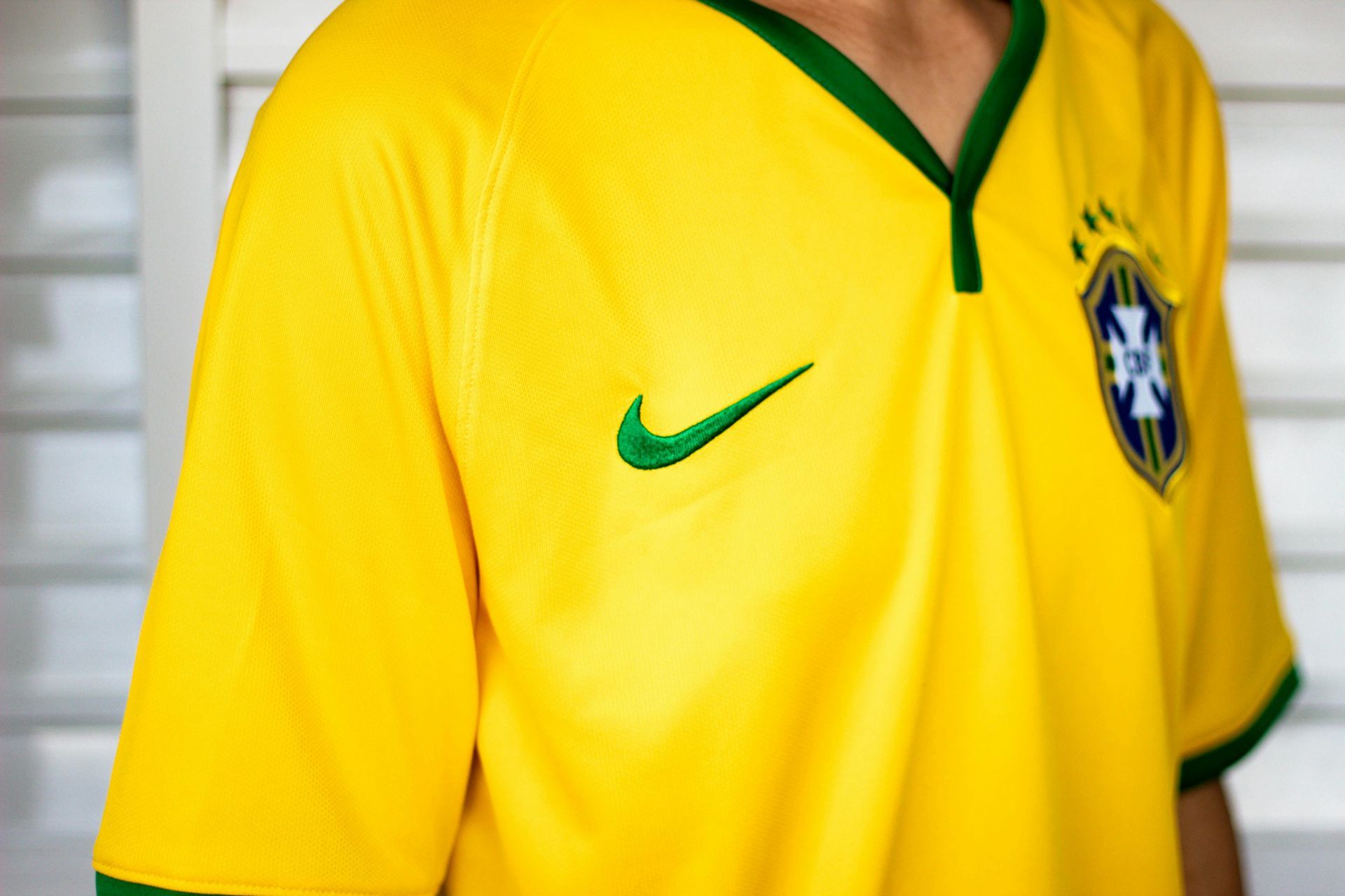 Yellow Brazil soccer jersey with green accents and Nike logo.
