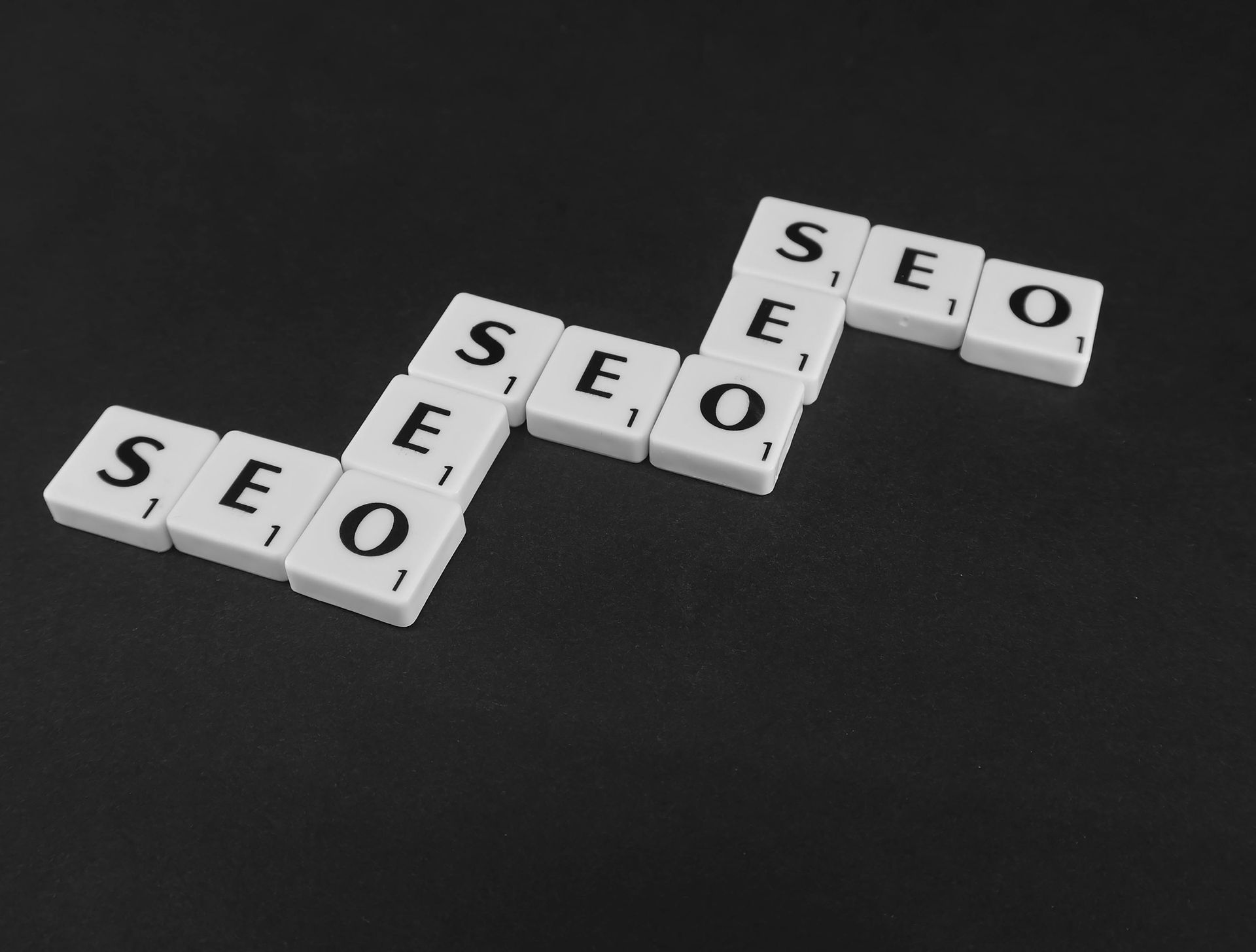 Scrabble tiles spelling out the word seo on a black background