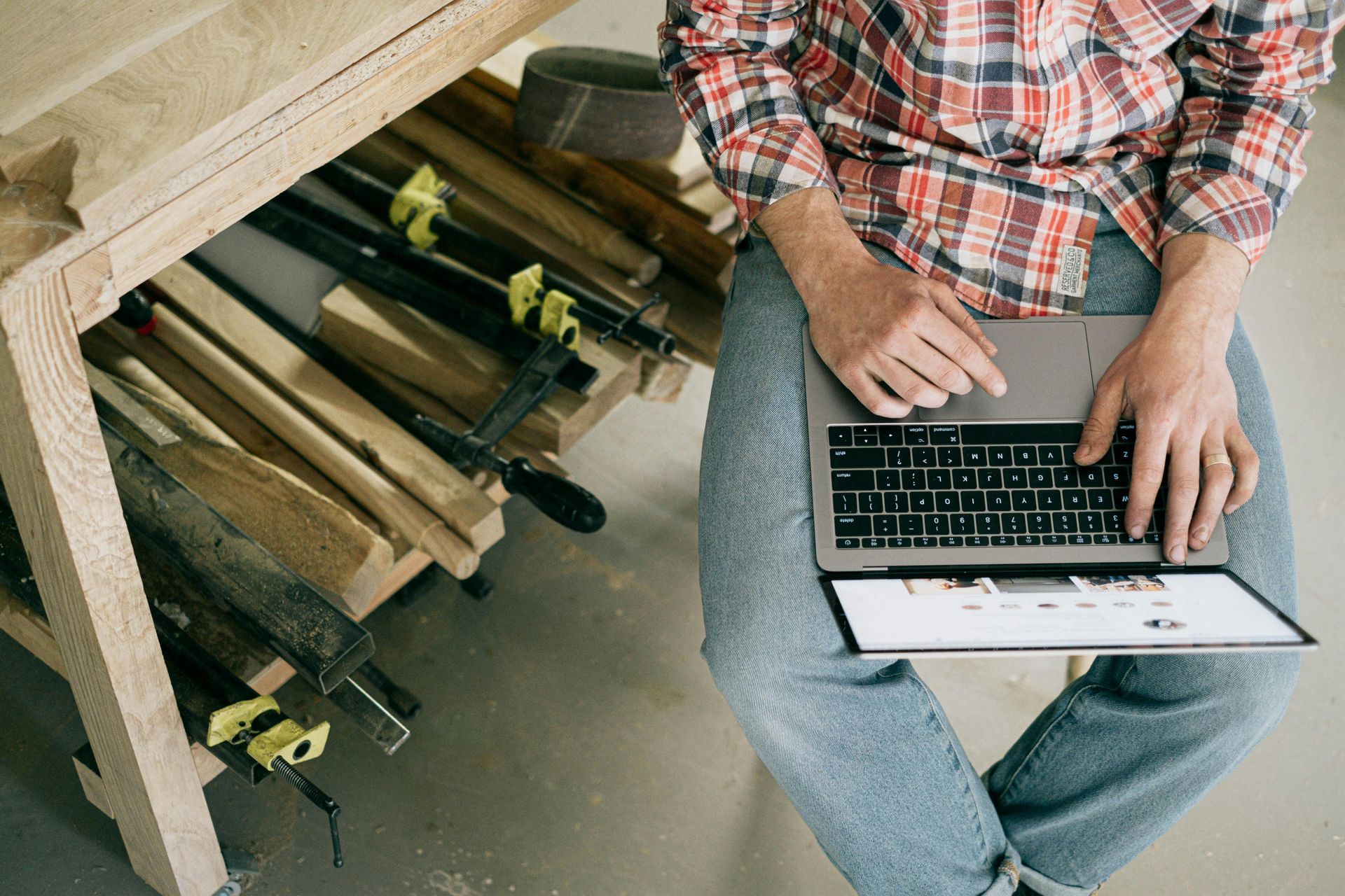 A man is sitting on the floor using a laptop computer.