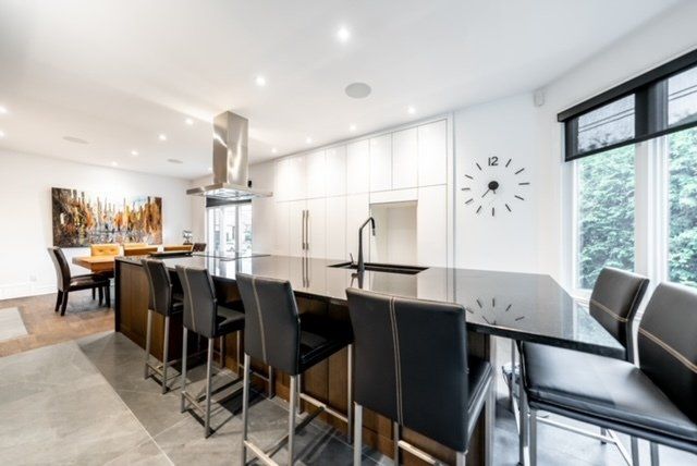 A kitchen with a large island and a clock on the wall.