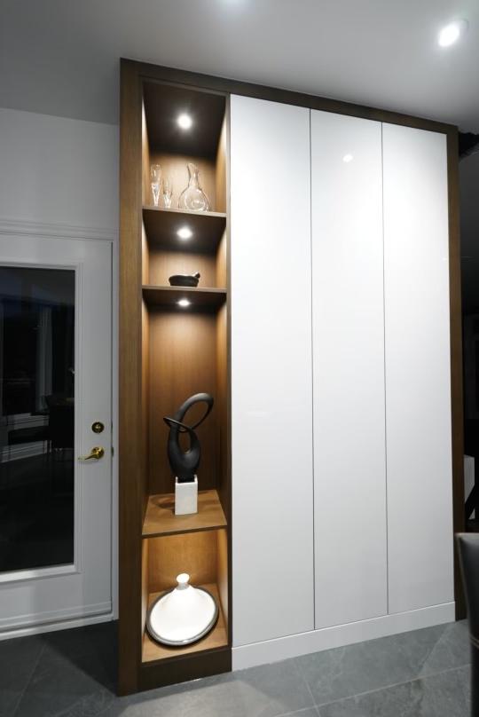 A room with white cabinets and wooden shelves