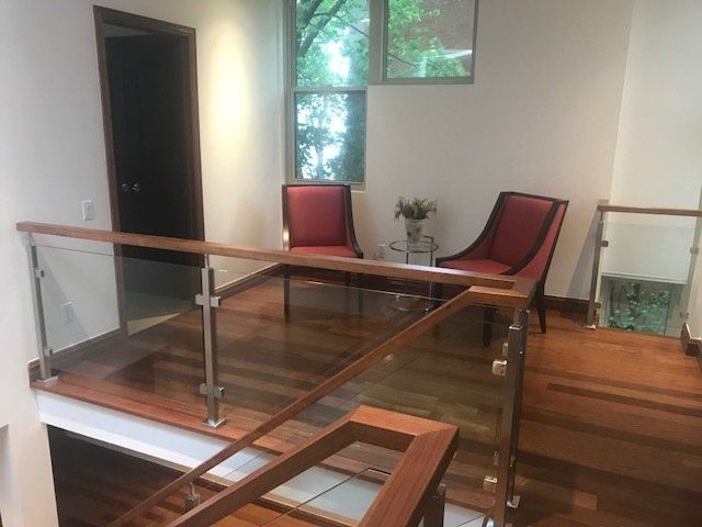 A living room with two chairs and a glass railing