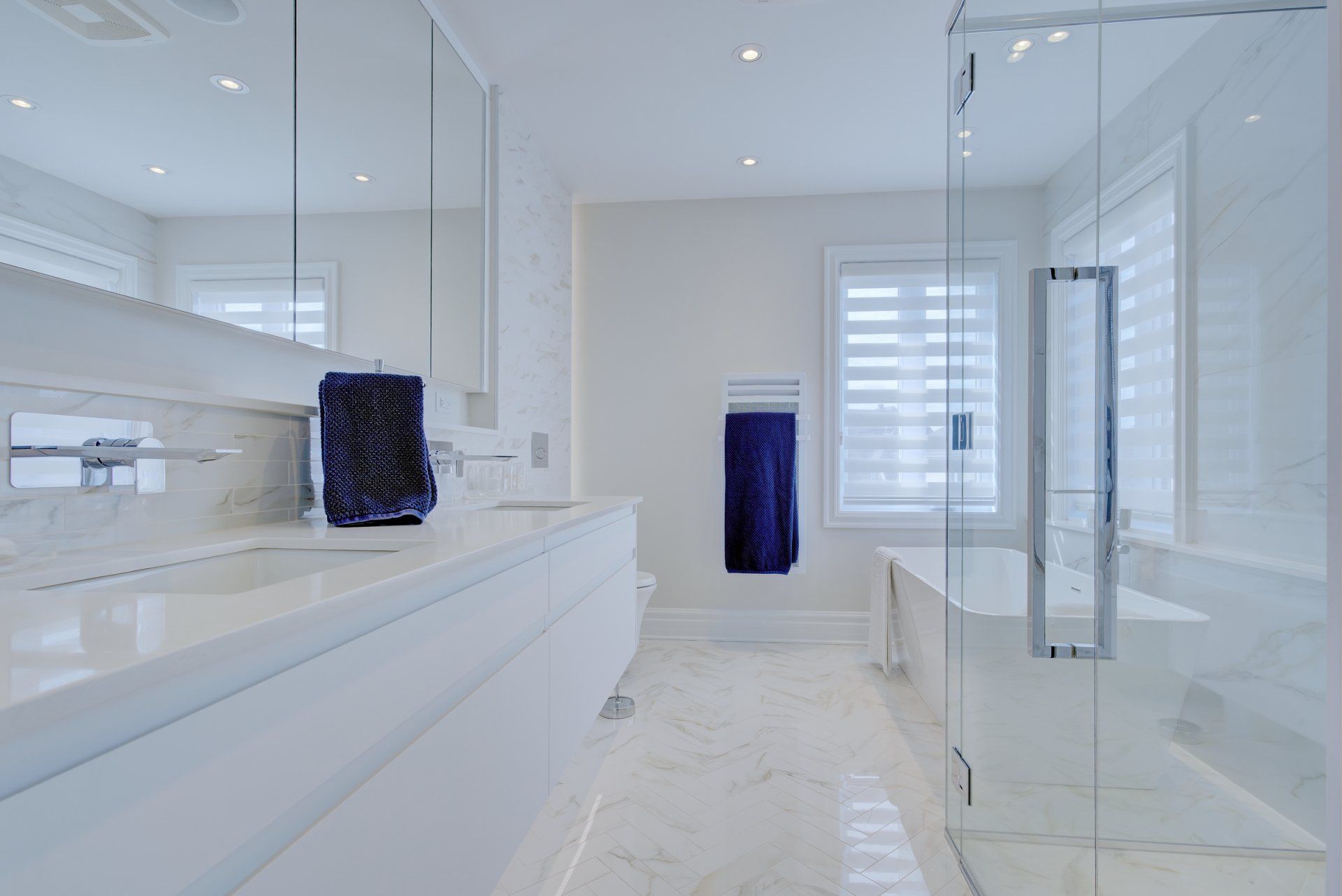 A bathroom with two sinks , a tub , and a walk in shower.