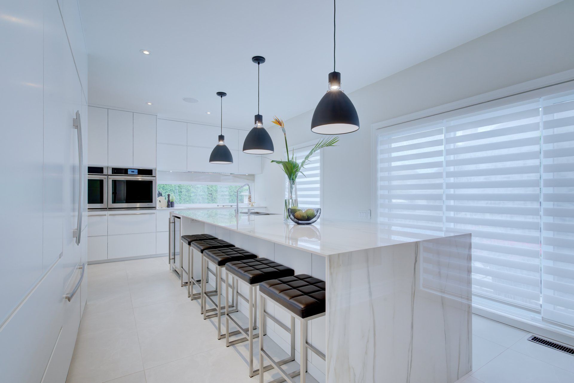 A kitchen with a long island and stools