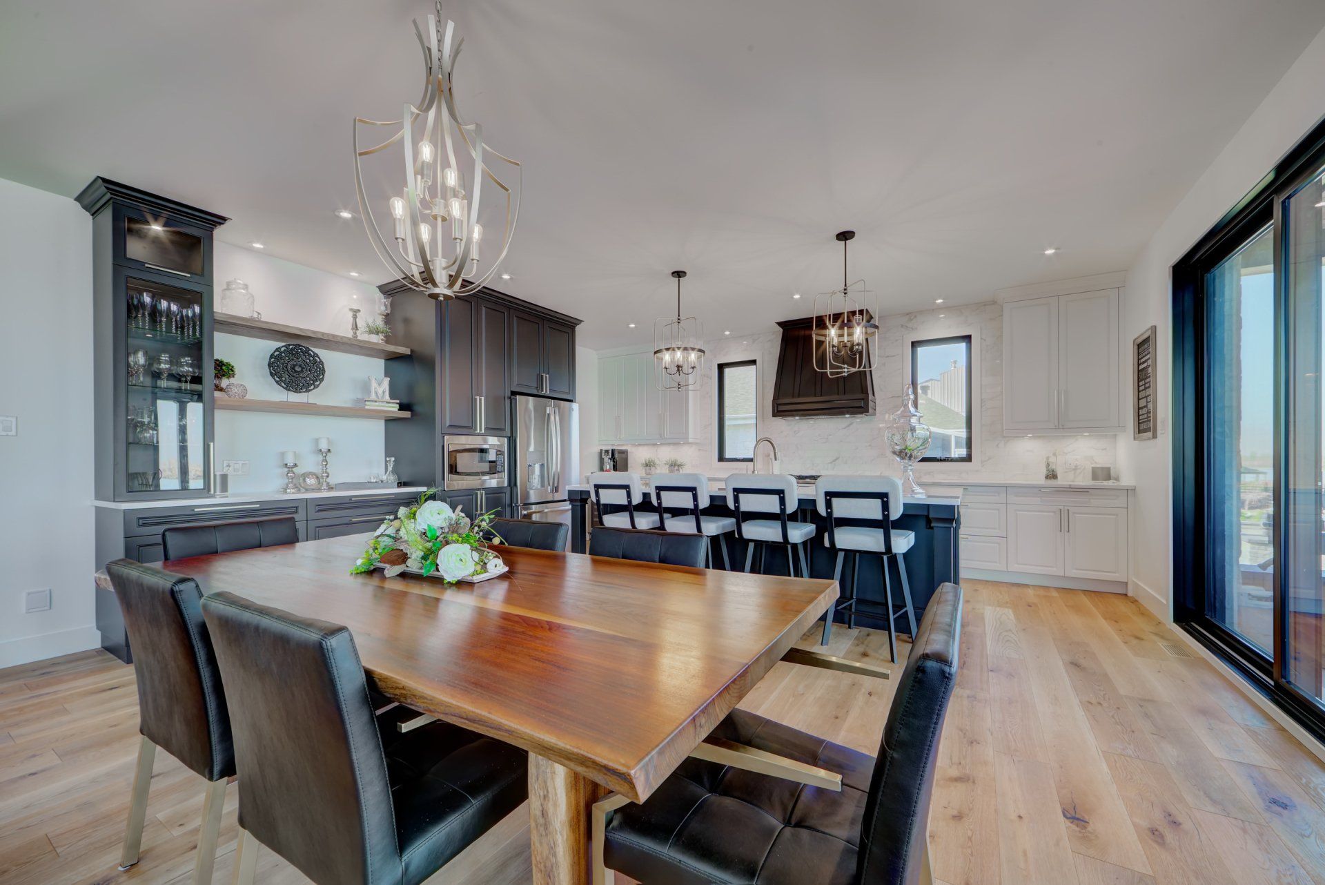 A dining room table and chairs in a kitchen with a chandelier.