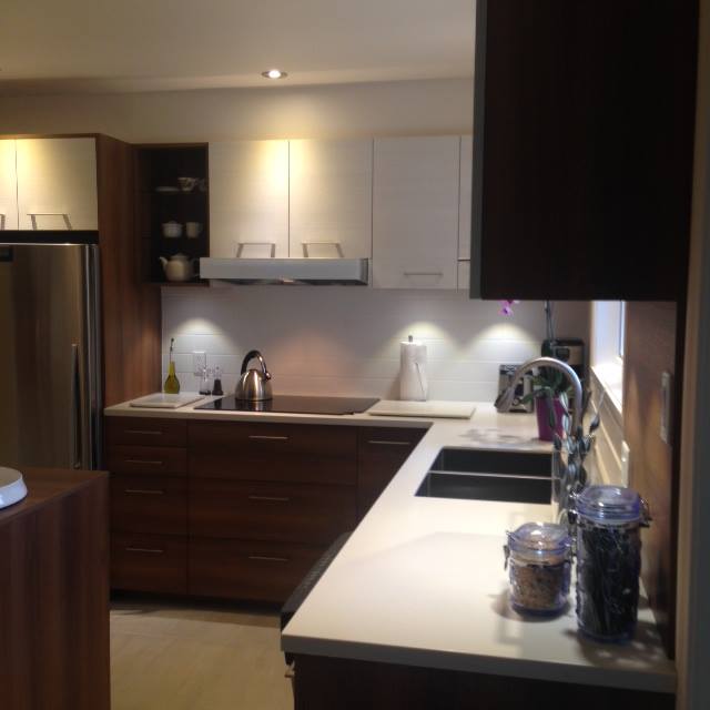 cuisine moderne avec armoires noires et comptoirs blancs