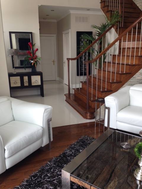 living room with white lazy boys and staircase in background