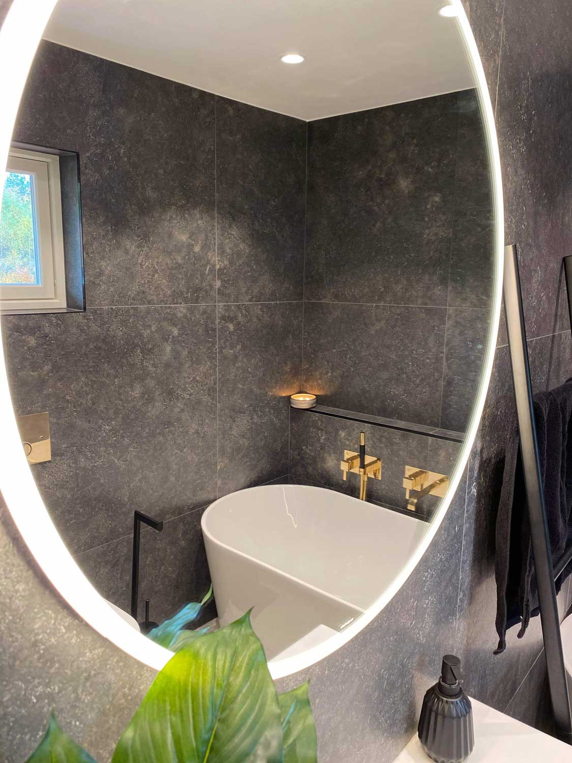 Nyoppusset baderom i nordisk stil med nærbilde av rundt speil som inspirasjon i 2021