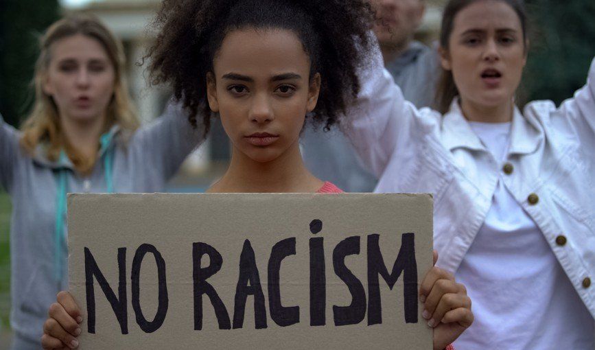 Woman holding sign which reads 