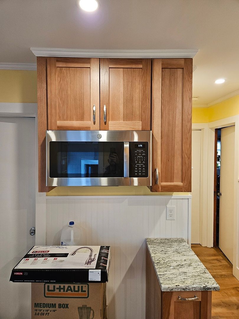 A kitchen with stainless steel appliances and wooden cabinets.