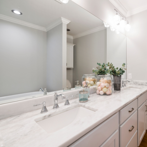 A bathroom with two sinks and a large mirror