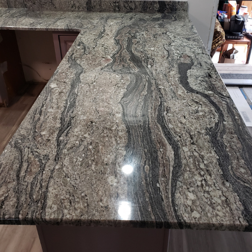 A close up of a granite counter top in a kitchen.