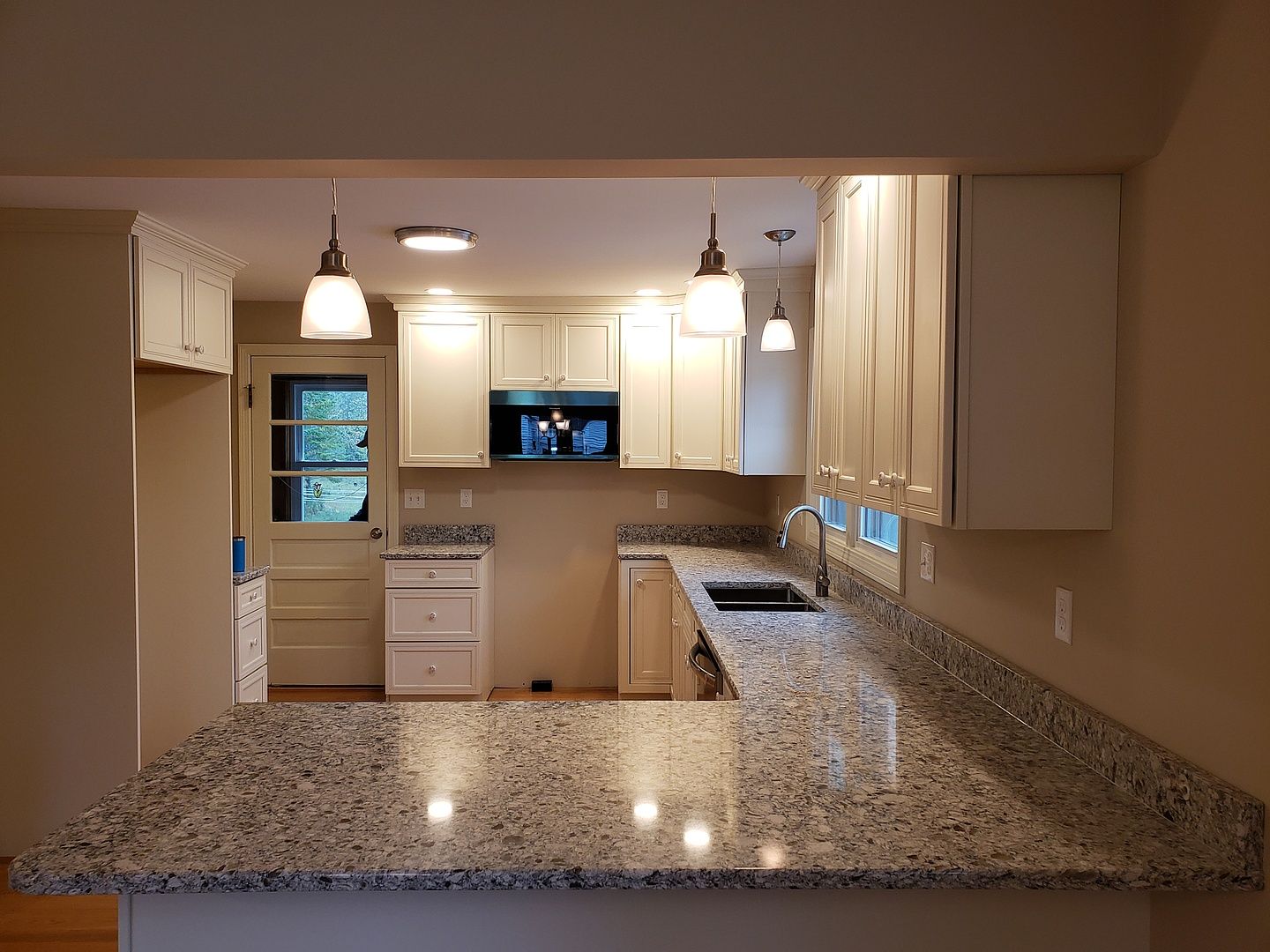 A kitchen with stainless steel appliances and gray cabinets