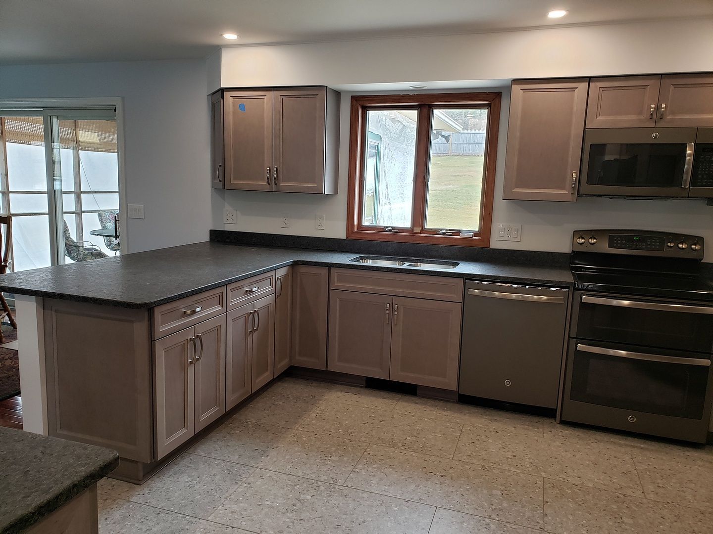 A kitchen with a large island and granite counter tops.