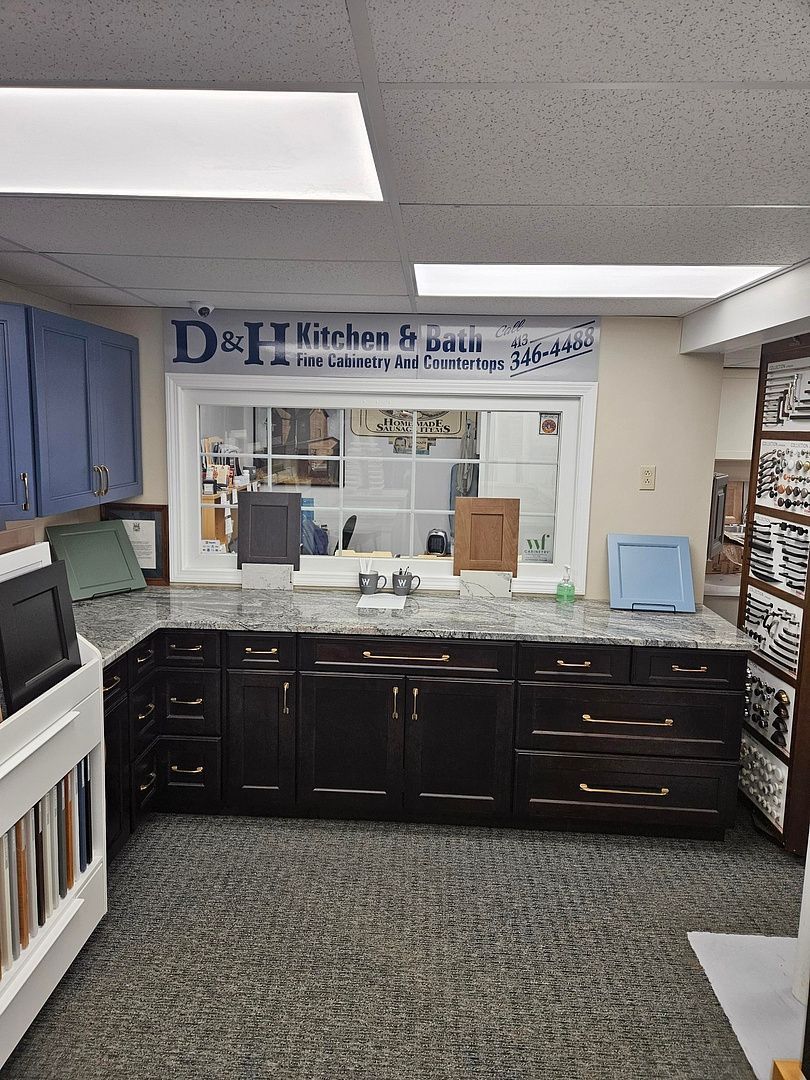 A kitchen with black cabinets and granite counter tops in a store.