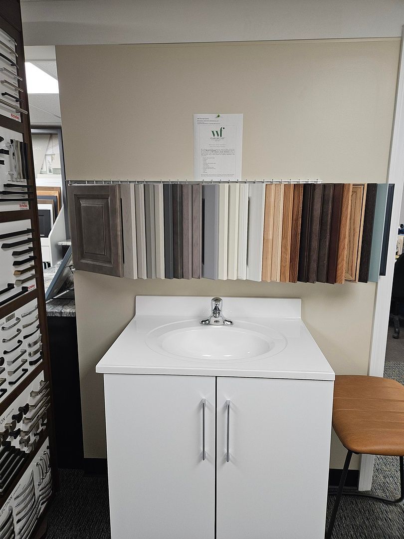 A bathroom vanity with a sink and a chair in a room.