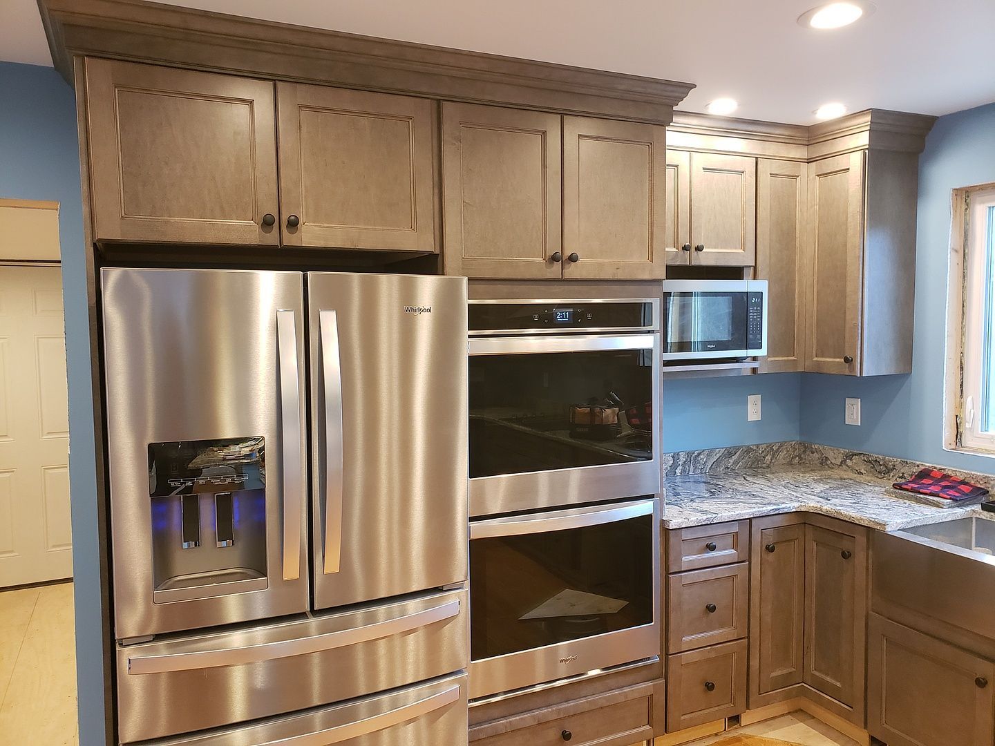 A kitchen with stainless steel appliances and gray cabinets