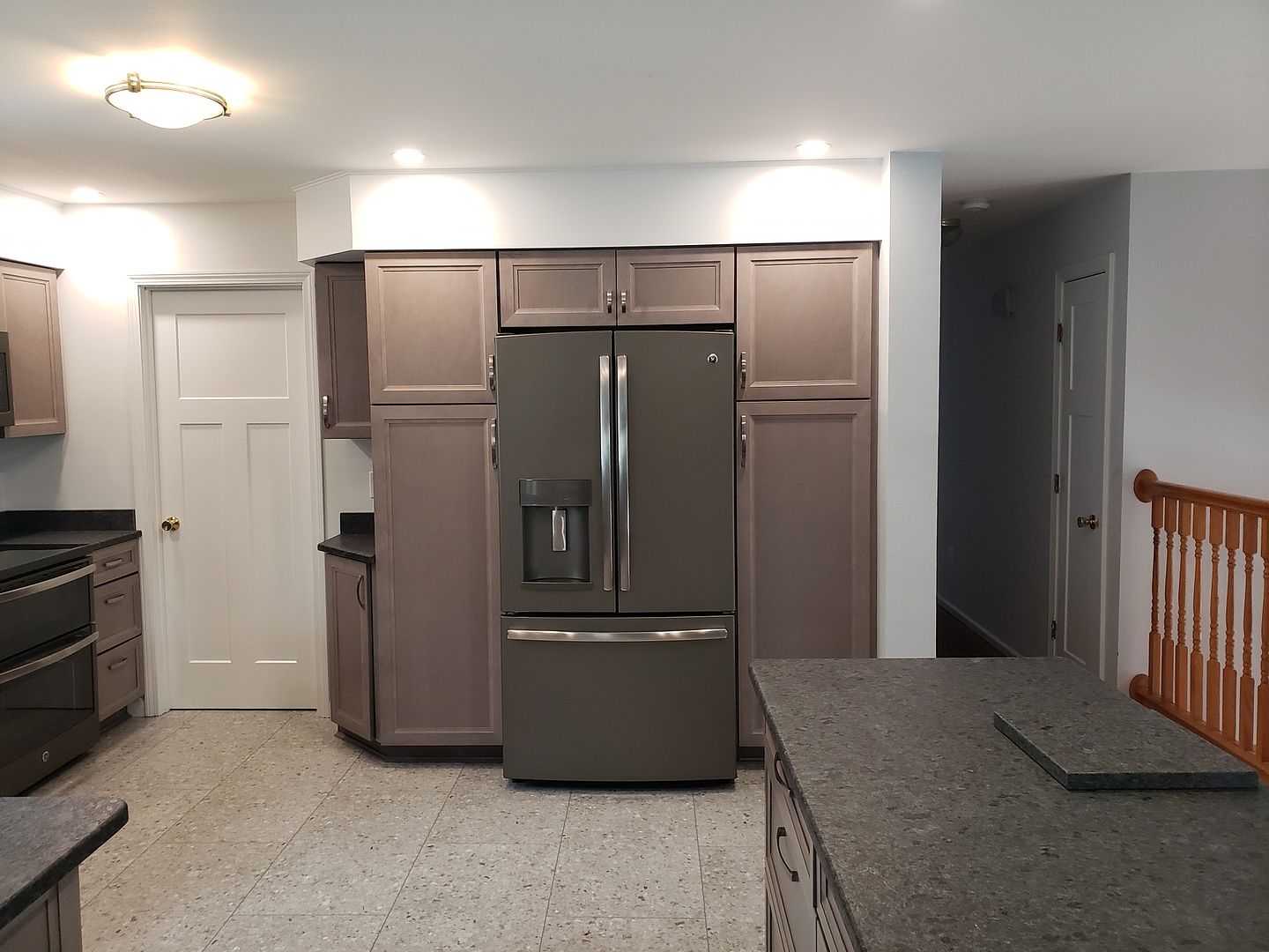 A long white cabinet with black handles is in a room.