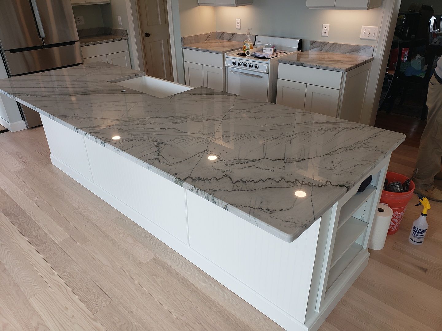 A kitchen with granite counter tops and white cabinets
