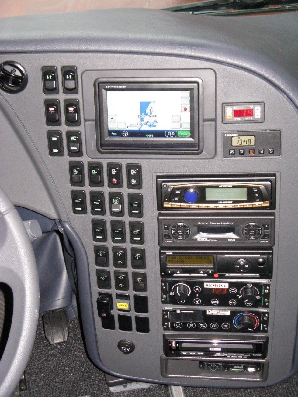 Cruscotto con schermo di navigazione, numerosi pulsanti e apparecchiatura audio in un veicolo.