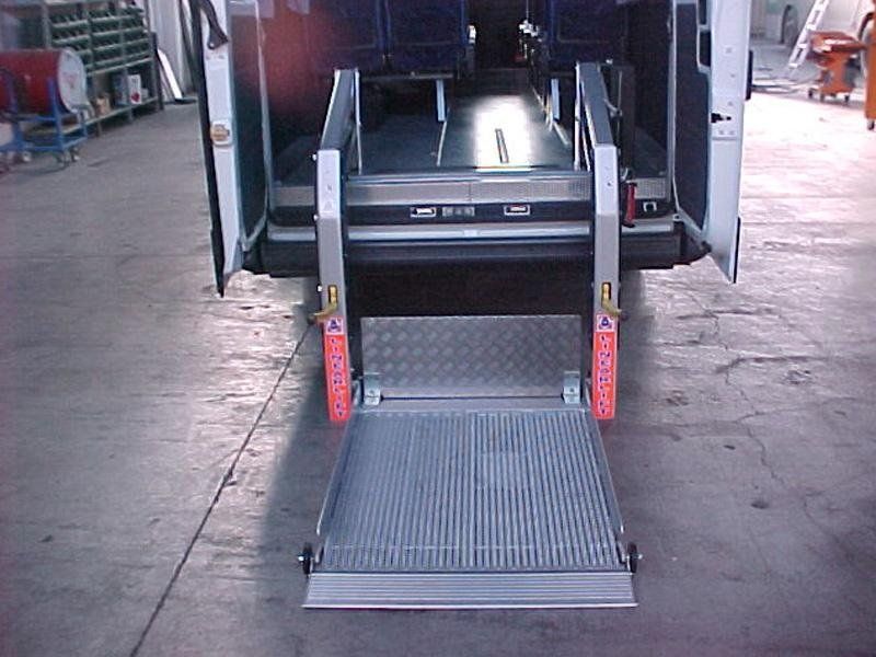 Sollevatore per sedie a rotelle estratto dal retro di un furgone. La rampa viene abbassata fino a terra.