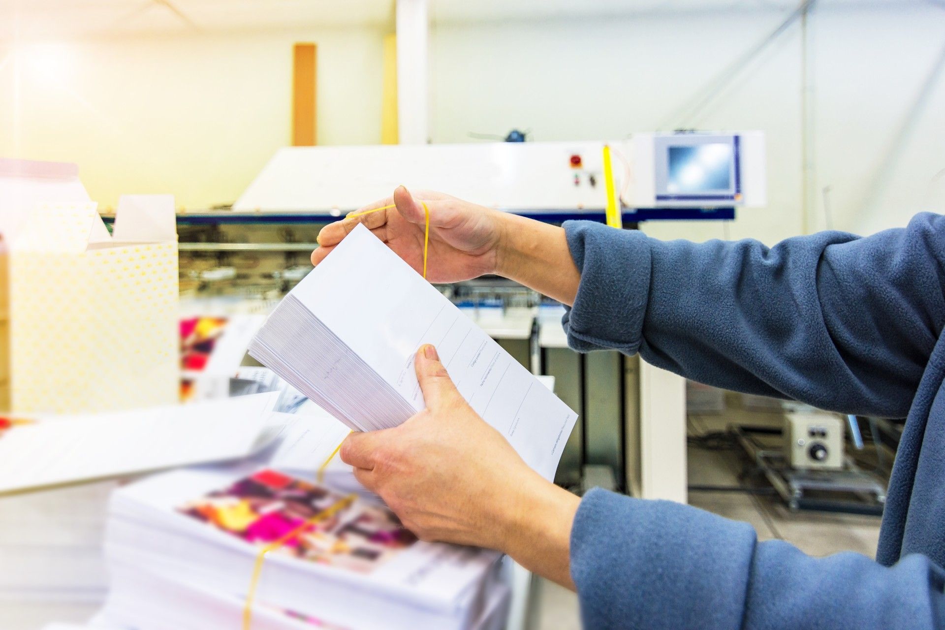 A person is holding a piece of paper in their hands in a factory.