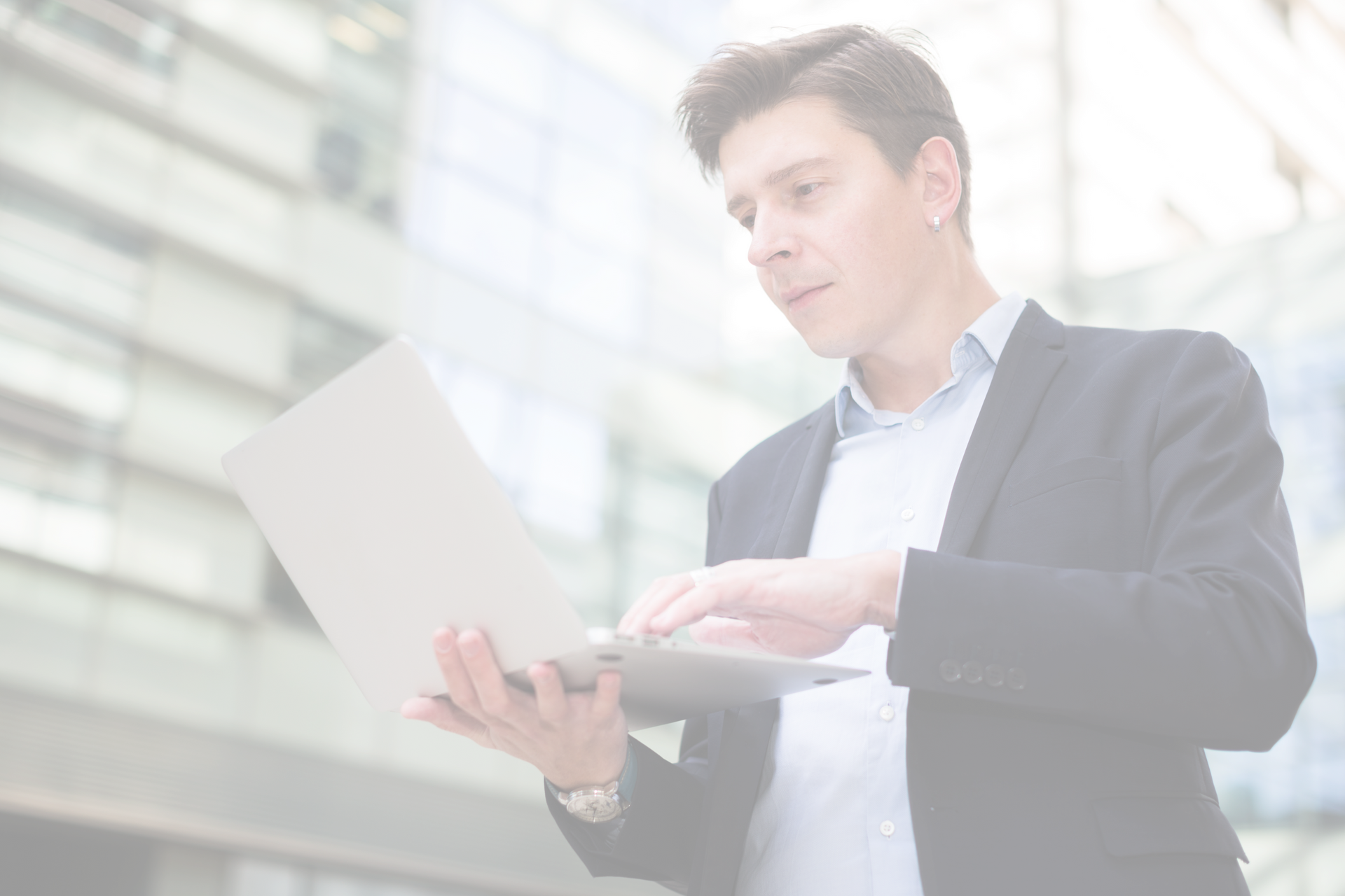 A man in a suit is using a laptop computer.