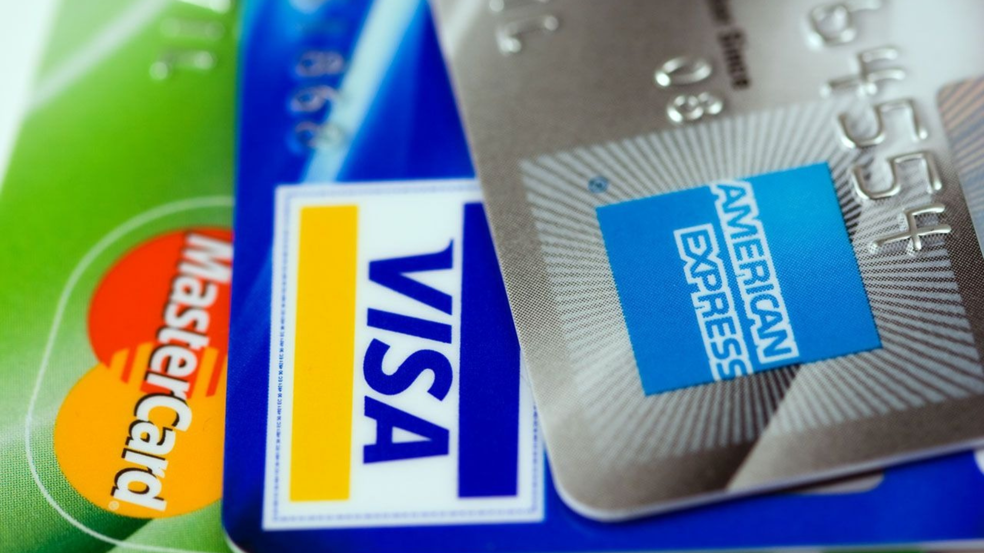 A visa and an american express credit card are stacked on top of each other