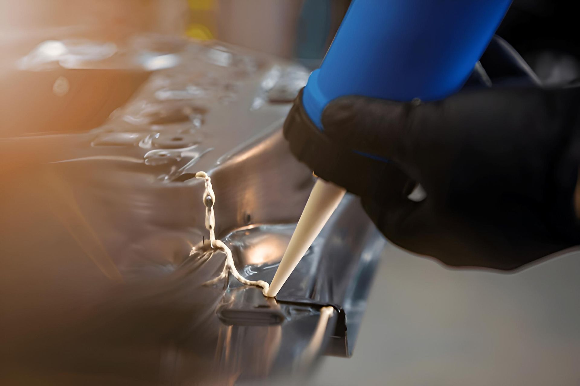 A Person is Applying Silicone Sealant to a Metal Surface — Mid Coast Bearing Centre in Gloucester, NSW